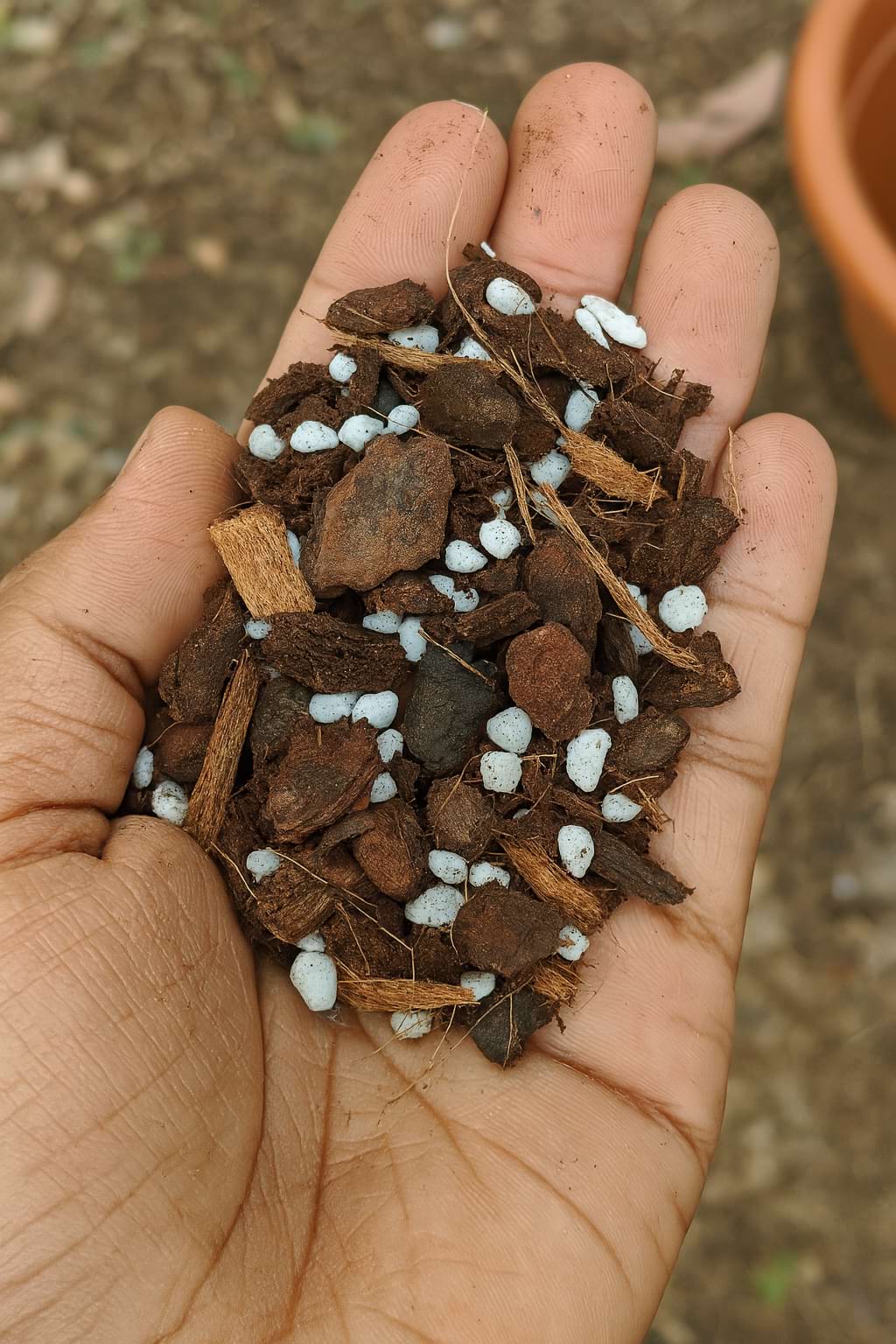 A close-up of a chunky aroid soil mix, showing large pieces of bark and perlite.